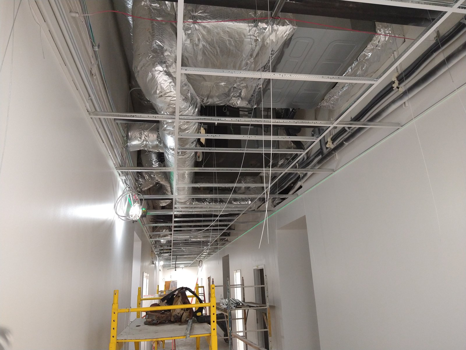 Construction worker installing ceiling tiles in office